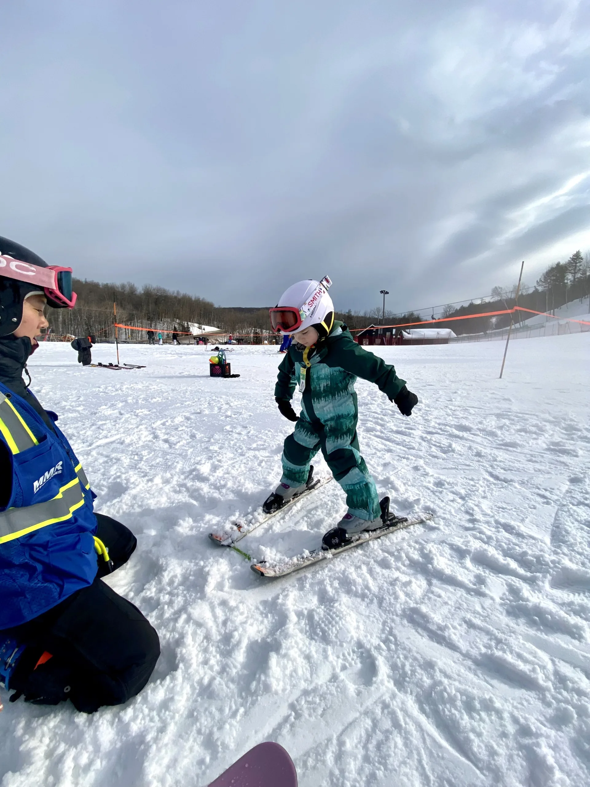 Ski instructor showing child how to ski.