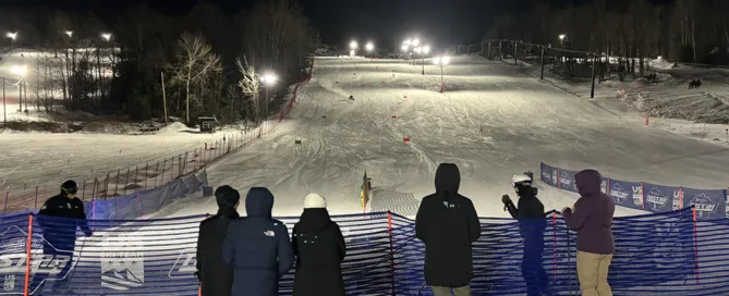 Ski hill at night with spectators at the bottom