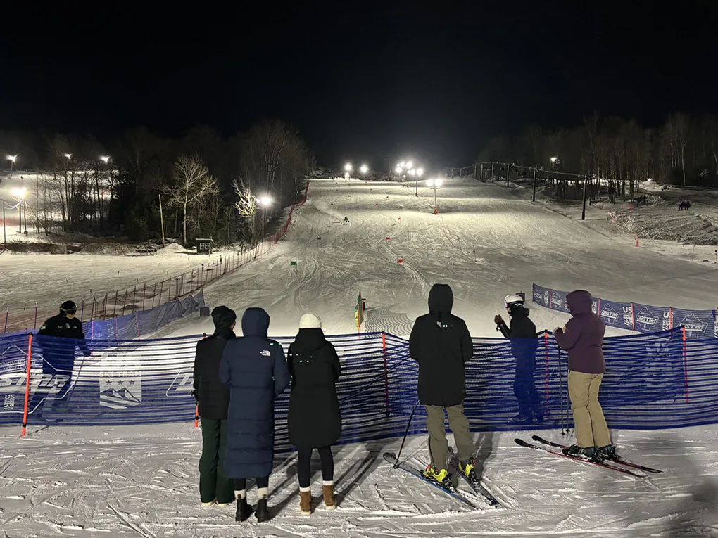 Ski hill at night with spectators at the bottom